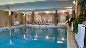 ein großer Swimmingpool mit Beleuchtung in einem Hotel in der Unterkunft Hotel Suprem in Băile Olăneşti