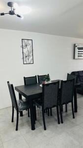 a black dining room table and chairs in a room at Casa cómoda in Estación Meseta +4 photos