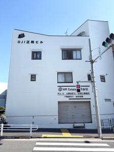 a white building with a sign on the side of it at Oji正和ビル in Tokyo