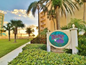 a sign in front of a resort with palm trees at Jamaica Royale in Sarasota