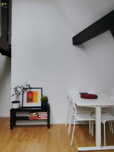 a white dining room with a table and chairs at Basel Rühige Zimmer mit grösse Doppelbett in Binningen