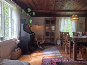 a living room with a table and a piano at Korsbacken in Tenhult