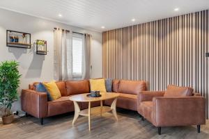 Una sala de estar con un sofá marrón y una mesa. en The Polar House - Free Parking, en Tromsø