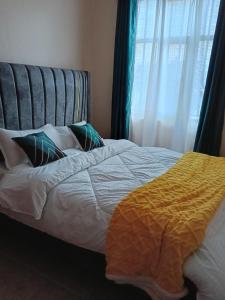een slaapkamer met een wit bed met kussens en een raam bij Lakesong Haven BNB, Naivasha, Kenya in Naivasha