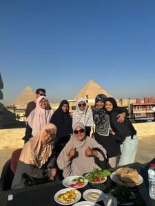 a group of people sitting around a table with food at Red Pyramids Hotel in Cairo