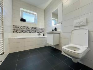 a white bathroom with a toilet and a sink at Apartment Richy Brasov in Braşov +9 photos