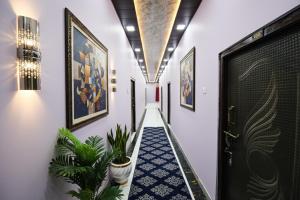 a hallway with plants and paintings on the walls at FabHotel Geeta Bhawan in Ayodhya +24 photos