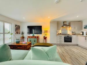 a living room with a couch and a kitchen at Elegant 2BR Retreat- Longbridge Shops, Rail & Hills in Longbridge