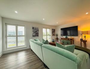 a living room with a couch and a flat screen tv at Elegant 2BR Retreat- Longbridge Shops, Rail & Hills in Longbridge