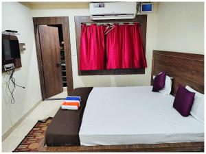 a bedroom with a bed with a red curtain at Near Sea Beach HOTEL SEA QUEEN RESORT INN ! Puri,Near Jagannath Temple- Fully Air conditioned Rooms ,Wifi and Restaurant, Parking Facilities - A Top Rated Hotel IN PURI in Puri