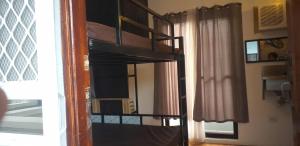 a bunk bed in a room with a window at Kua's Pad Batangas Room in Lian