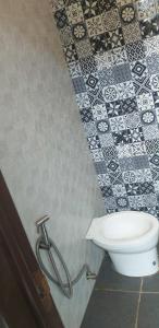a bathroom with a toilet and a black and white tiles at Kua's Pad Batangas Tent in Calatagan +25 photos