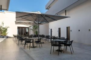 a group of tables and chairs with a large umbrella at Agkyra Boutique Hotel in Rhodes Town