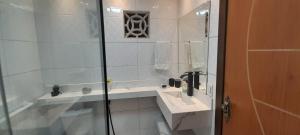 a white bathroom with a sink and a shower at Casa há 300m do PARQUE DA CIDADE - COP 30 in Belém +23 photos