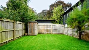 a backyard with a fence and a green lawn at Hazelbury Cottage in Wilton +27 photos