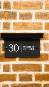 a sign on the side of a brick wall at Hazelbury Cottage in Wilton +27 photos