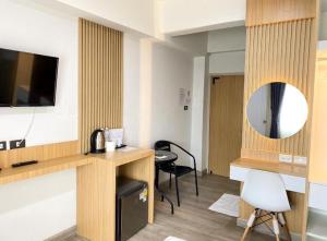 a hotel room with a desk and a mirror at PG Ryoichi Hotel in Chiang Rai +17 photos