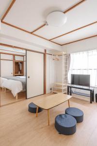 un soggiorno con tavolo, letto e scrivania di Hakata apartment a Fukuoka
