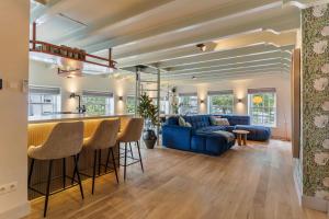 a living room with a bar and a blue couch at Luxury Harbour Apartment with Sauna and Jacuzzi in Medemblik