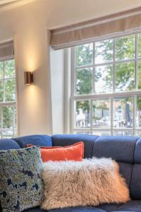 a blue couch with pillows in a room with windows at Luxury Harbour Apartment with Sauna and Jacuzzi in Medemblik +51 photos