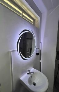 ein Badezimmer mit einem weißen Waschbecken und einem Spiegel in der Unterkunft Eirene Place Relax and Recharge in Pusok + 10 Fotos