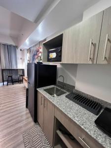 eine Küche mit einer Spüle und einem schwarzen Kühlschrank in der Unterkunft Eirene Place Relax and Recharge in Pusok