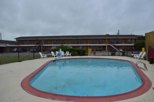 einem großen Pool vor einem Gebäude in der Unterkunft Americas Best Value Inn Crosstimbers in Stephenville