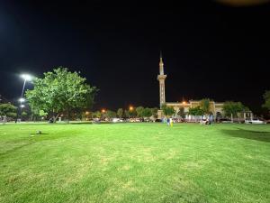 een groot grasveld met 's nachts een klokkentoren bij Tanja Pearl in Tanger