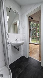 a bathroom with a sink and a mirror at Dock 2 - tolles Ferienhaus für bis zu 6 Personen mit Kaminofen und Sauna - Haustiere herzlich willkommen in Nordhorn