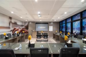 Una sala de conferencias con mesas, sillas y una pantalla. en Msharef Almoden hotel, en Riad 41 fotos más