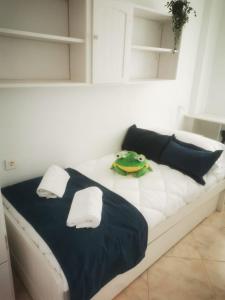 a white bed with a green toy on top of it at Apartamento con vistas a toda la bahia in Puerto de Mazarrón