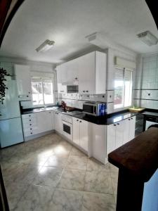 a large white kitchen with white cabinets and appliances at Apartamento con vistas a toda la bahia in Puerto de Mazarrón