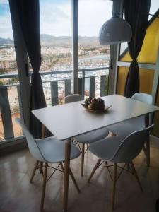 a white table with chairs and a plate of fruit on it at Apartamento con vistas a toda la bahia in Puerto de Mazarrón +5 photos
