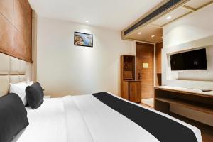 une chambre d'hôtel avec un lit et une télévision à écran plat dans l'établissement Super Townhouse Chhatarpur Near Metro Park, à Jāmb