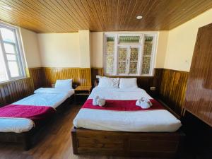 佩林Hotel Tashiling Stay的一间卧室,有两张床,床上有毛巾