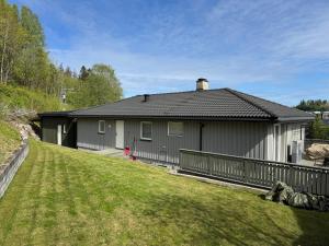 a house with a fence in front of a yard at Modern apartment in Drammen