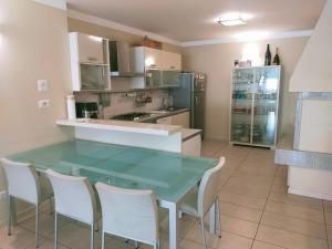 a kitchen with a glass table and white chairs at Mondarco in Serravalle