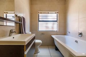 a bathroom with a tub and a toilet and a sink at Modern 3-Bed Apartment Perfect for Family & Groups in Vosburg +25 photos