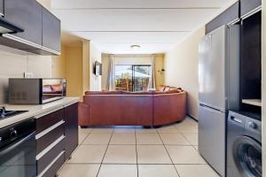 a kitchen with a living room with a couch at Modern 3-Bed Apartment Perfect for Family & Groups in Vosburg