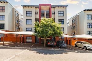 a building with two cars parked in a parking lot at Modern 3-Bed Apartment Perfect for Family & Groups in Vosburg