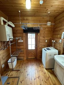 a kitchen with a washer and dryer in a log cabin at Furano Private Villa Runway 15 in Wada +22 photos