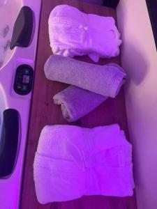 un groupe de serviettes violettes et une paire de ciseaux dans l'établissement Appartement jacuzzi - Love Room, à Lyon