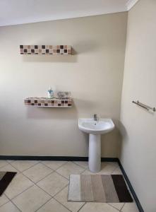 Un baño con un lavabo blanco en una habitación. en Catalina Bay Beach Retreat - Dolphin Inn, en Hibberdene 3 fotos más