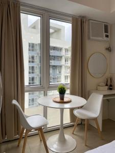 a table and two chairs in a room with a window at Kasara Pasig Staycation in Manila