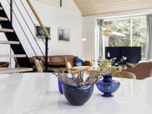 two blue vases sitting on a table with flowers at 10 person holiday home in Væggerløse-By Traum in Marielyst +28 photos