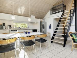a kitchen with a table and chairs and a staircase at 10 person holiday home in Væggerløse-By Traum in Marielyst