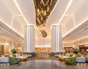 a rendering of a hotel lobby with tables and chairs at Grande Centre Point Prestige Bangkok in Bangkok