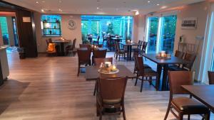 a restaurant with wooden tables and chairs and tables and windows at Ferienhaus Strandlöper Reiners in Horumersiel +18 photos
