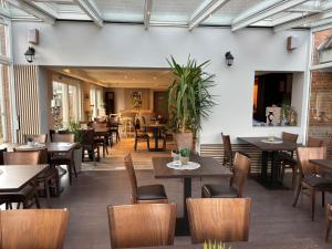 an empty restaurant with tables and chairs and tablesktop at Ferienhaus Strandlöper Reiners in Horumersiel