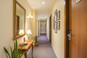 a corridor of a hallway with a mirror and a table at FabHotel Royal International - Nr Mumbai International Airport in Mumbai